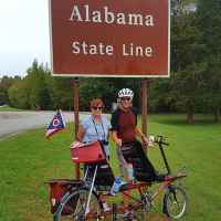 Cyclists riding a tandem bike at the Tennessee - Alabama State Line