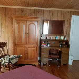 Spacious Garden Room with a queen size bed, table and chairs, desk, rocker and TV hutch.