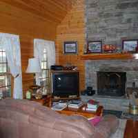 Huge living room with cathedral ceiling with dish TV/VCR and a working, wood-burning fireplace.